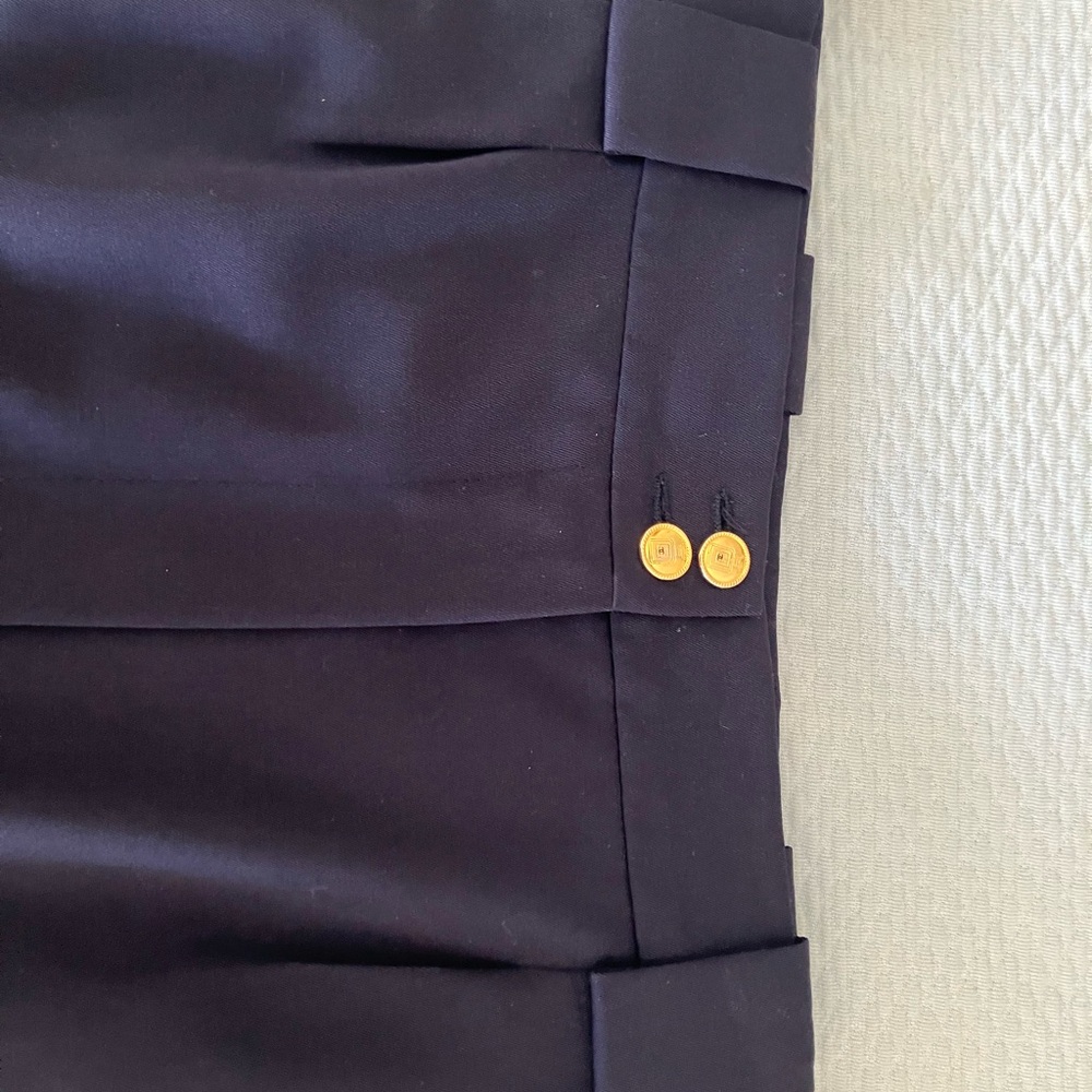 CHANEL Navy pencil skirt with kick pleats & gold perfume bottle buttons.